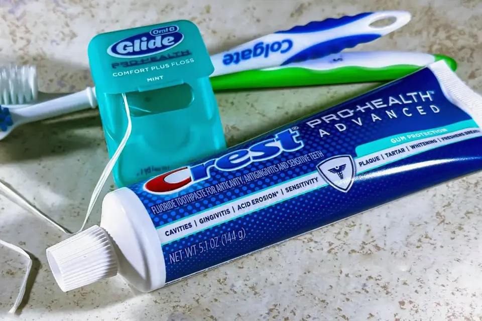 A small toothbrush and tube of pet-safe toothpaste laid on a white background